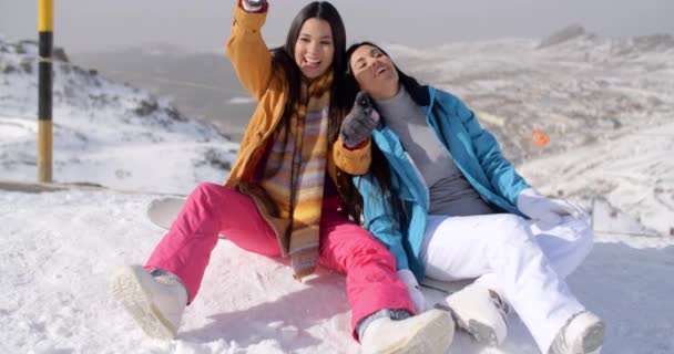 Mujeres sentadas en la cima de la montaña en nieve — Vídeo de stock