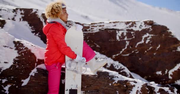 Mosolygó fiatal nő kezében snowboard — Stock videók