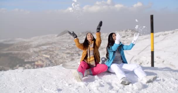 Vrouwen zitten op de bergtop in de sneeuw — Stockvideo