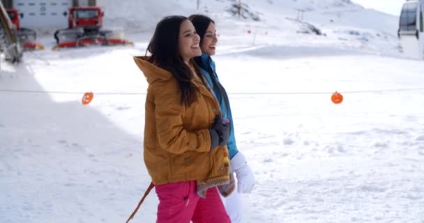 Femmes marchant dans la neige à la station — Video