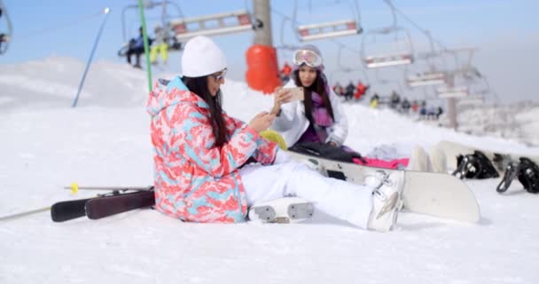 Жінки сидять на вершині гори в снігу — стокове відео