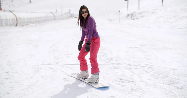 Frau balanciert auf Snowboard — Stockfoto