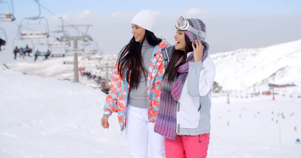 Women walking through snow at resort — Φωτογραφία Αρχείου