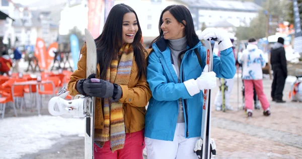 Women in ski resort holding snowboards — Φωτογραφία Αρχείου