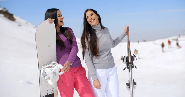 Women in ski resort holding snowboards — Zdjęcie stockowe