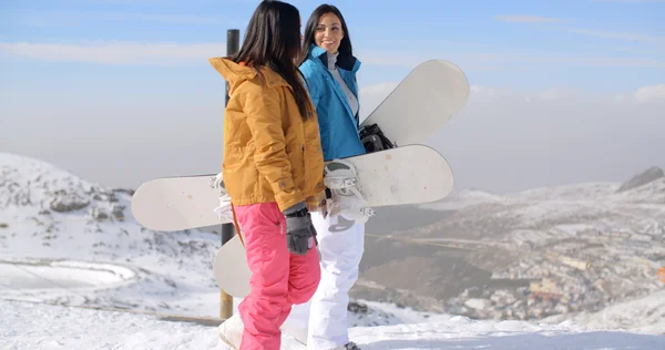 Mulheres que transportam snowboards na montanha — Fotografia de Stock