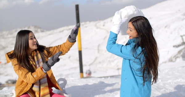 Amigos do sexo feminino jogando na neve — Fotografia de Stock