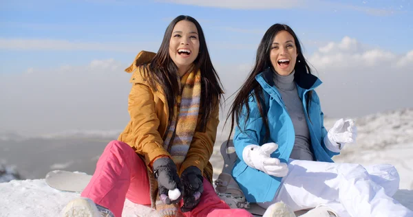 雪の山の頂上に座っている女性 — ストック写真