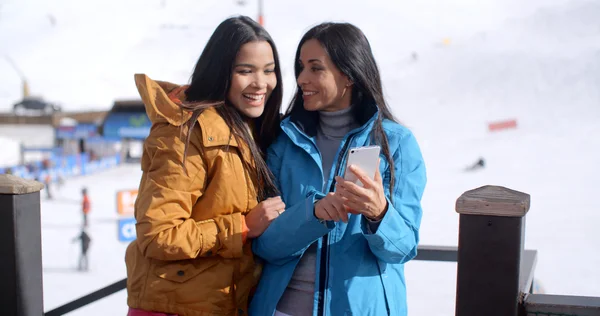 Women checking phone on ski slope — Foto Stock