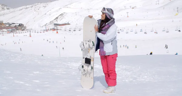 Mujer de pie esperando con snowboard en la montaña — Foto de Stock