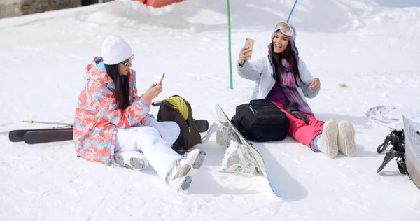 Amis se détendre avec snowboards assis dans la neige — Photo