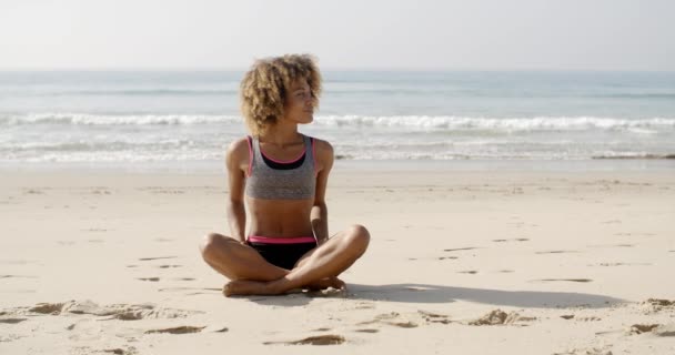 Mujer en ropa deportiva relajante en la playa — Vídeos de Stock