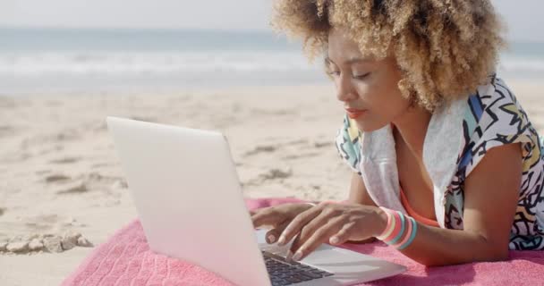 Frau tippt am Strand auf Laptop — Stockvideo