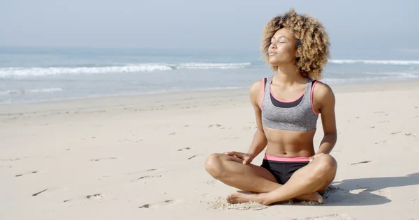 Mujer en pose de yoga en la playa — Foto de Stock