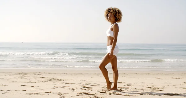 Mujer en bikini blanco bronceándose en la playa — Foto de Stock