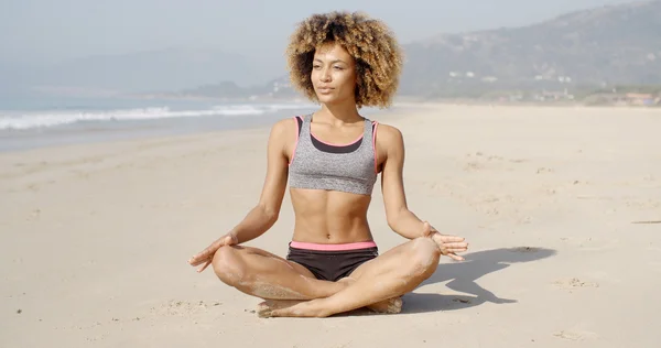 Chica meditando en la costa del mar — Foto de Stock