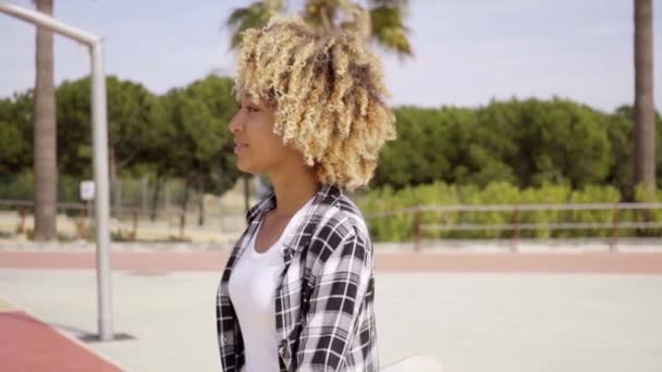 Femme marchant avec skateboard dans les mains — Video