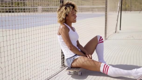 Femme assise sur skateboard au skate park — Video