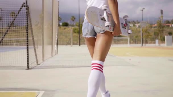 Donna che cammina con lo skateboard in mano — Video Stock