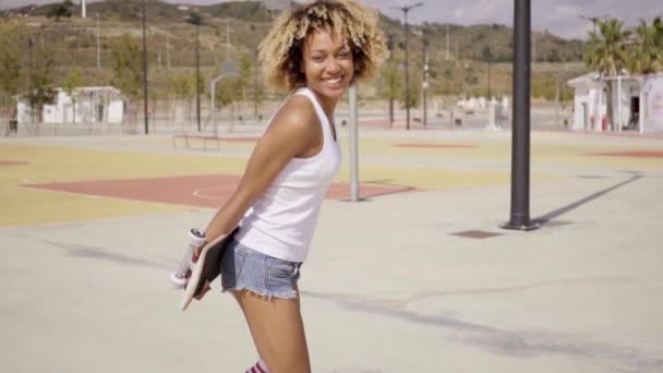 Woman walking with skateboard in hands — Stock Video