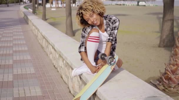 Žena sedí na městských parapet s longboard — Stock video