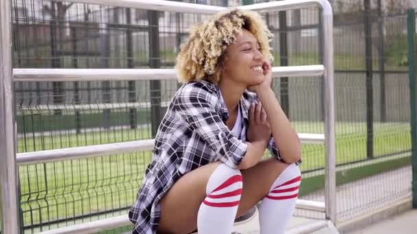 Femme assise sur skateboard au skate park — Video