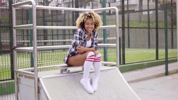 Femme assise sur skateboard au skate park — Video