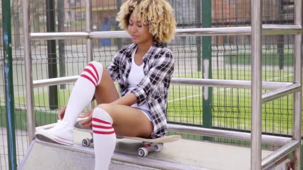 Mujer sentada en monopatín en el parque de skate — Vídeo de stock