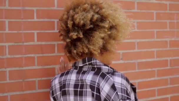 Жінка ходить по цегляній стіні — стокове відео