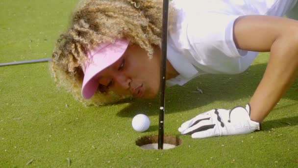 Жінка в спортивному одязі грає в гольф — стокове відео