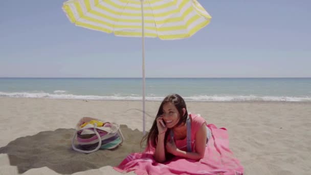 Femme couchée sur la plage sous parapluie — Video