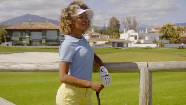 Женщина позирует на поле для гольфа — стоковое видео