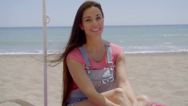 Woman sitting on beach and daydreaming — Stock video