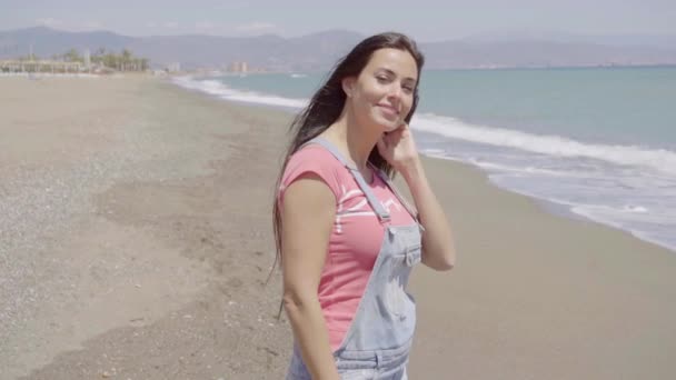 Mujer caminando en la playa en un día soleado — Vídeos de Stock