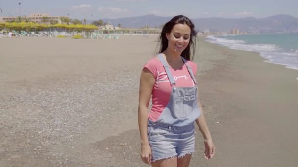 Güneşli gün kumsalda yürüyen kadın — Stok video