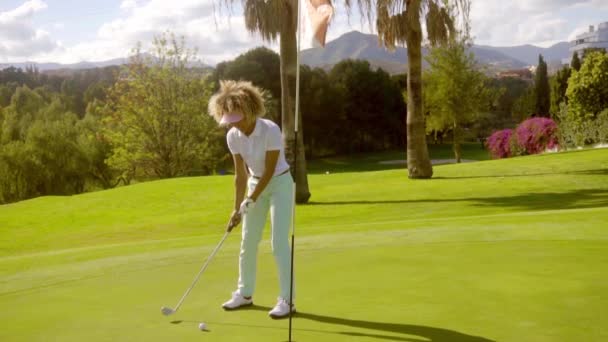 Женщина в спортивной одежде играет в гольф — стоковое видео