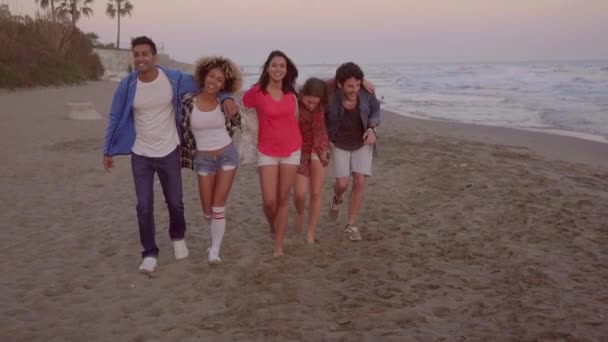 Jonge groep van mensen lopen op strand — Stockvideo