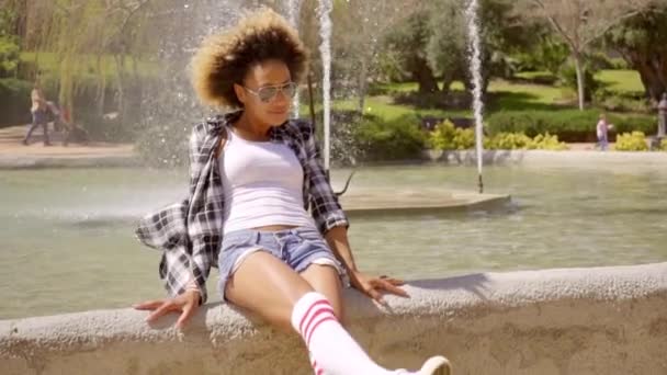 Nő ül ellen fountain — Stock videók