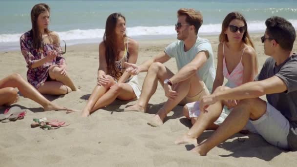 Menschen sitzen auf Sand und reden miteinander — Stockvideo