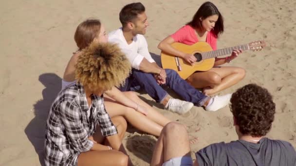 Beautiful girl playing guitar for friends — Stock Video