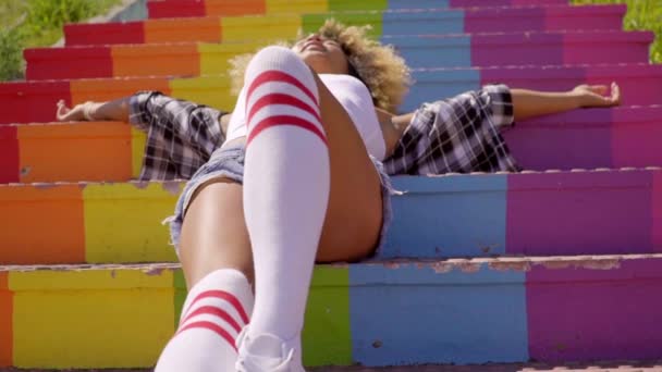 Mulher deitada em escadas coloridas — Vídeo de Stock