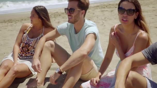 People sitting on sand and talking with each other — Stock Video