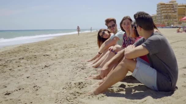 Mensen zitten op zand en praten met elkaar — Stockvideo