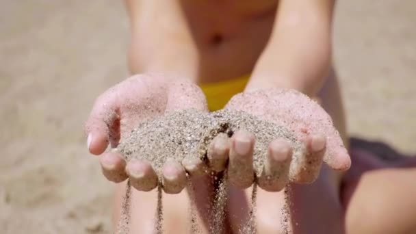 Woman holding handful of beach sand — Stockvideo