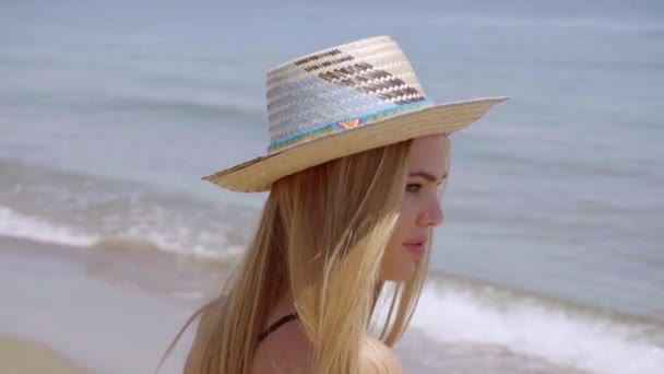 Mujer joven en sombrero de sol en la orilla del mar — Vídeo de stock