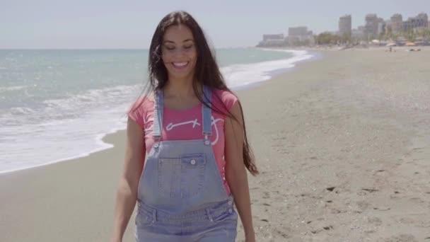 Femme marchant près de la plage avec des bâtiments — Video