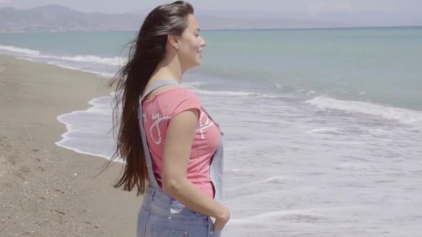 Женщина, идущая вдоль пляжа — стоковое видео