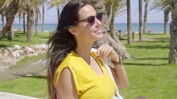 Femme en lunettes de soleil marchant sur la promenade en bord de mer — Video