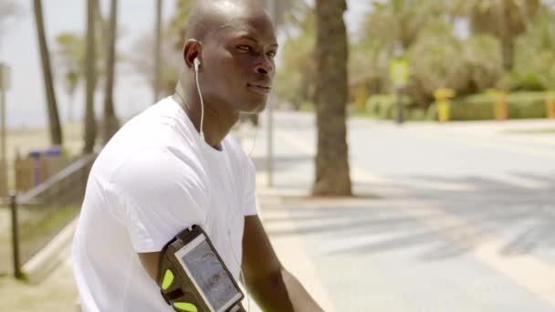 Homme assis sur parapet et écoutant de la musique — Video