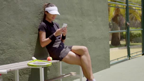 Теннисист проверяет мобильный — стоковое видео
